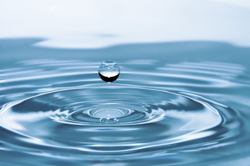 A drop of water falling into a large body of water